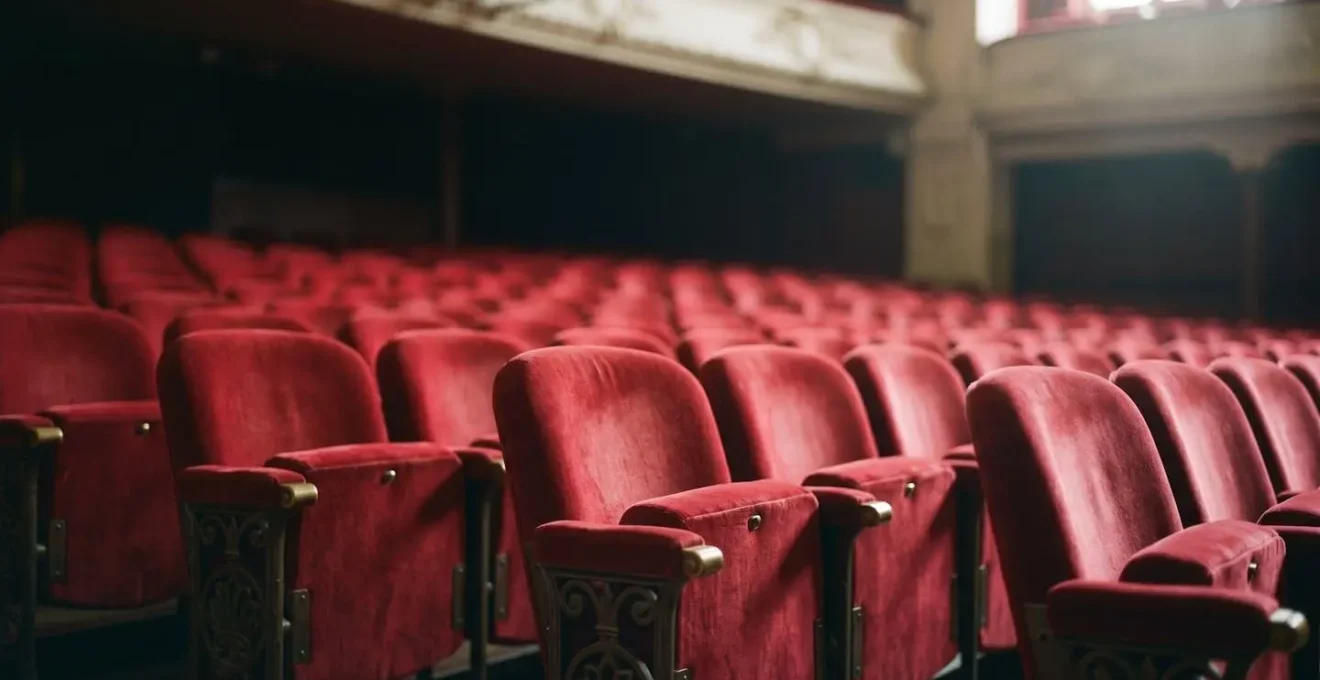 Rangées de fauteuils rouges dans une grande salle de spectacle parisienne vue depuis la scène