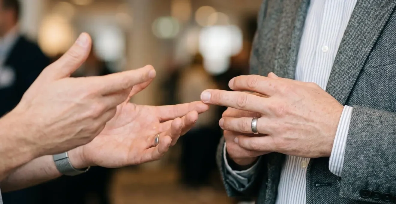 Interaction professionnelle détendue lors d'un événement de networking avec échange authentique et sourires